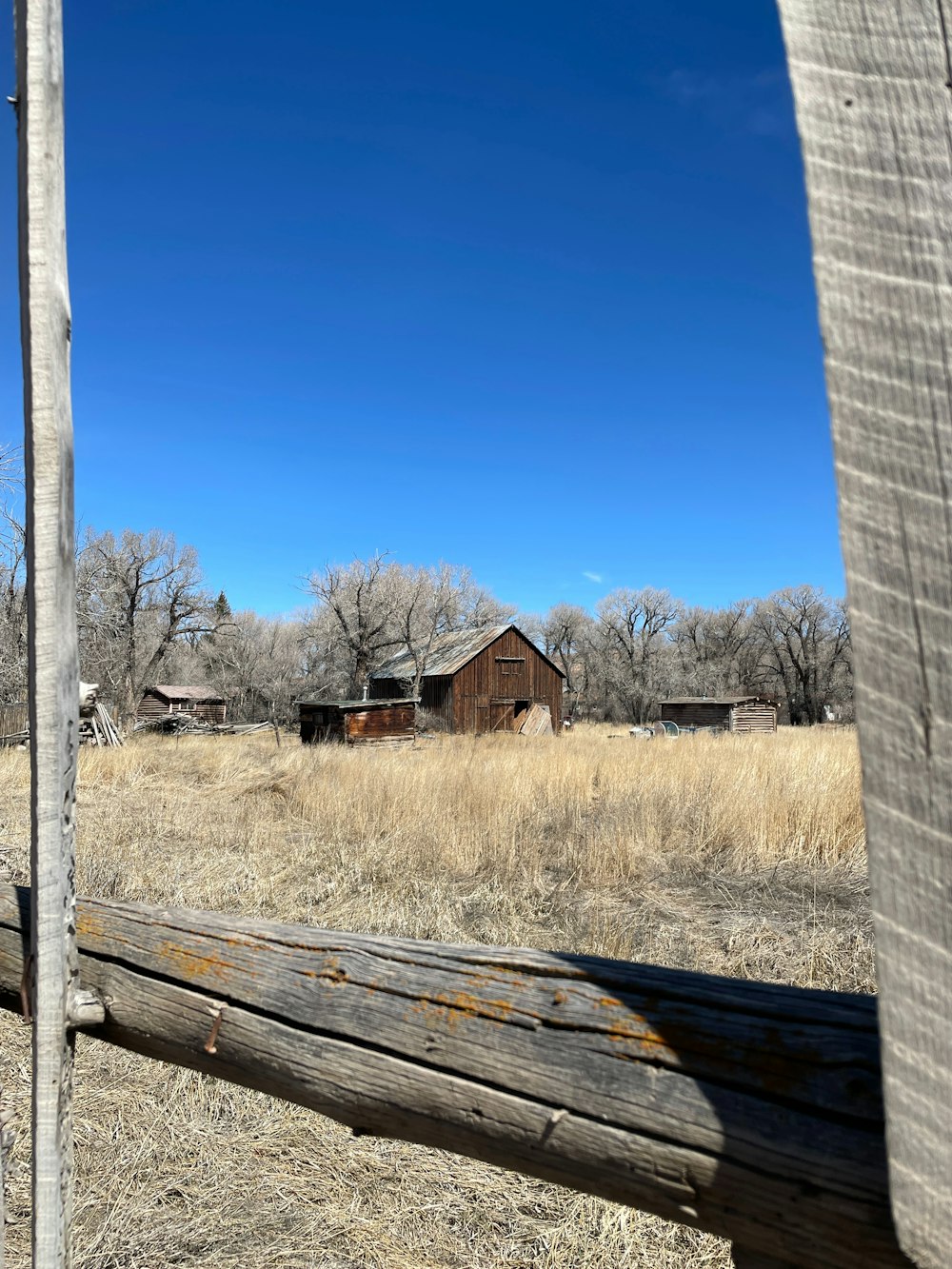 an old barn in the middle of a field