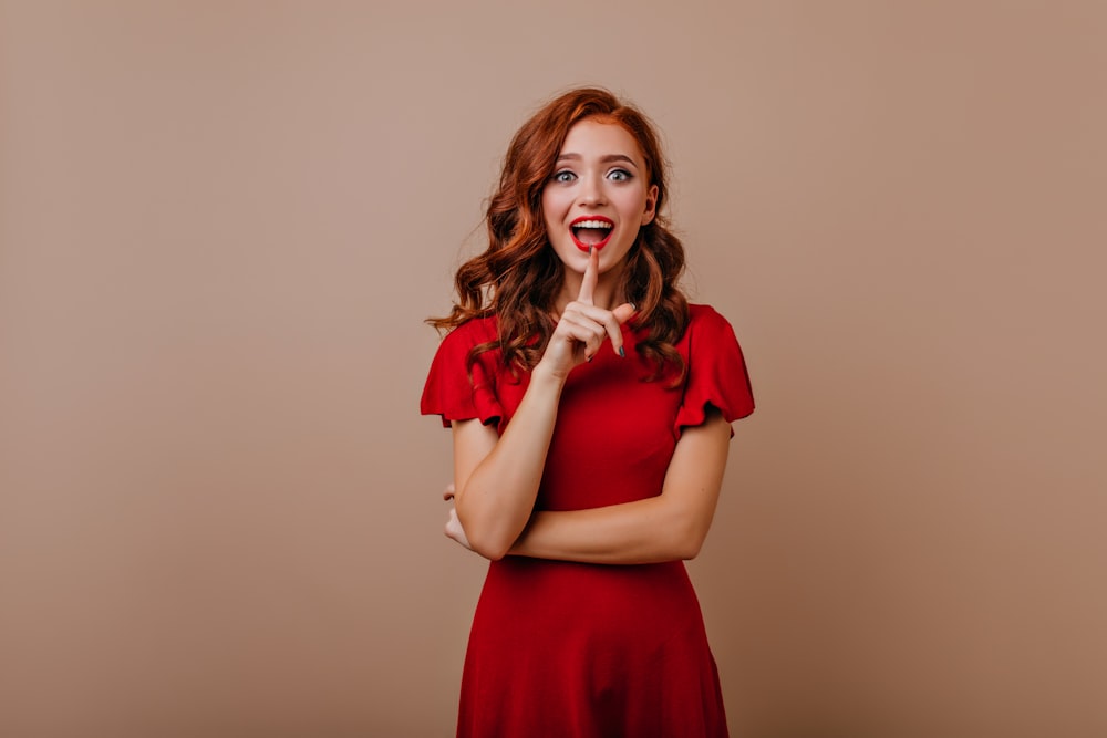 a woman in a red dress making a funny face