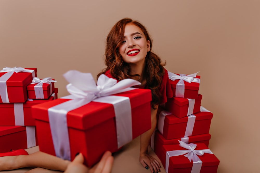 a woman holding a red and white gift box