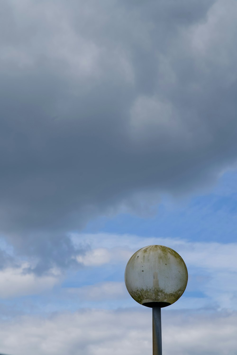 a street light with a cloudy sky in the background