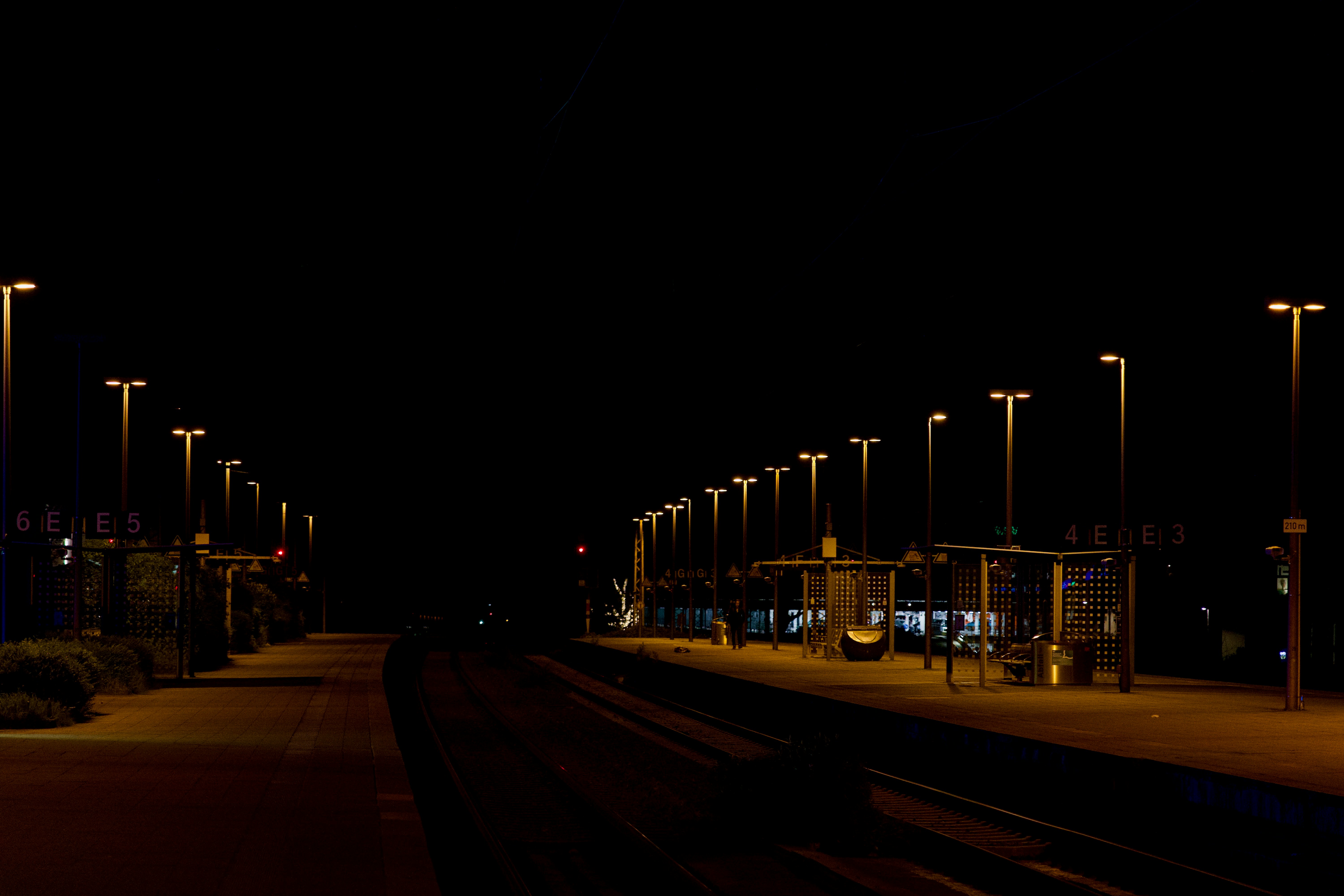 a train station at night with a train on the tracks