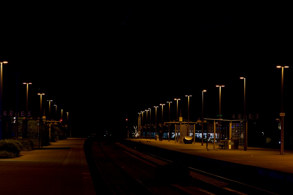 a train station at night with a train on the tracks