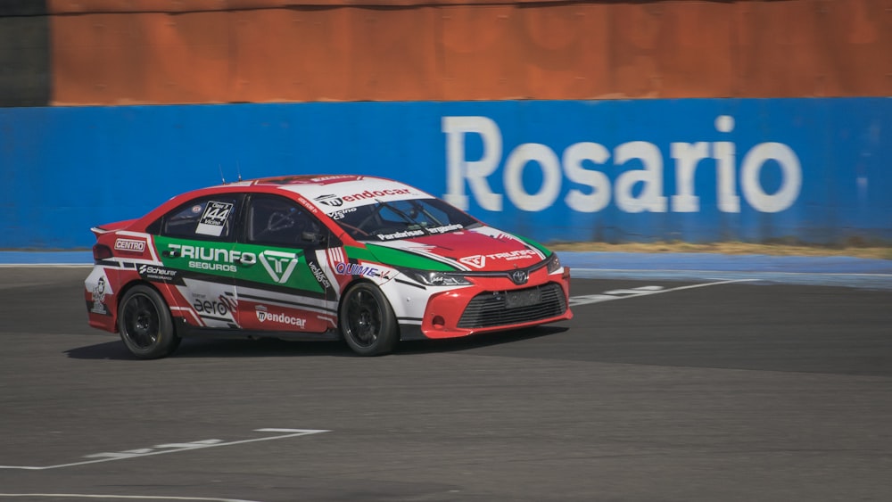 a red and green car driving on a race track