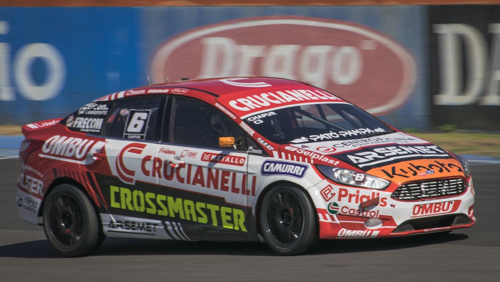 a red and white car driving on a race track