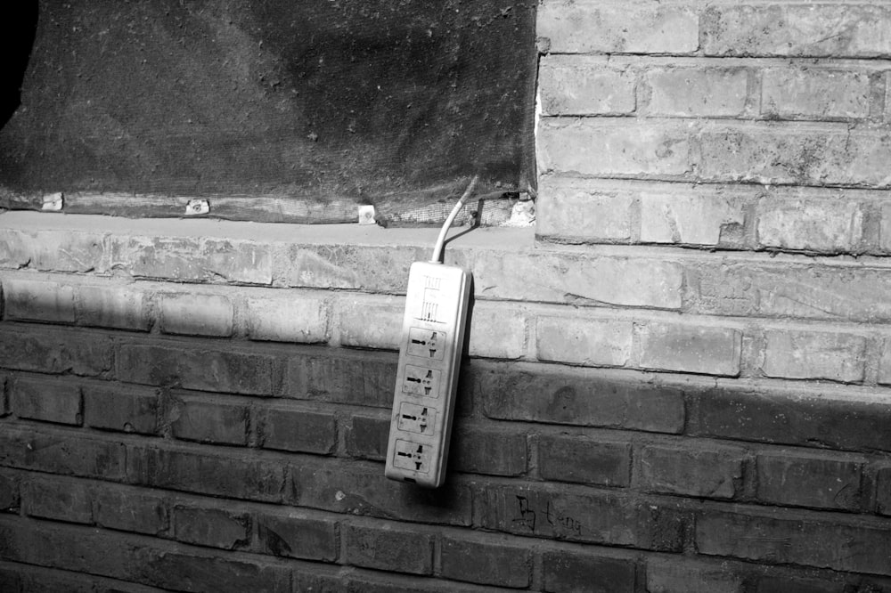 a brick wall with a phone attached to it