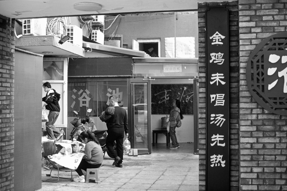 a black and white photo of people sitting on a bench