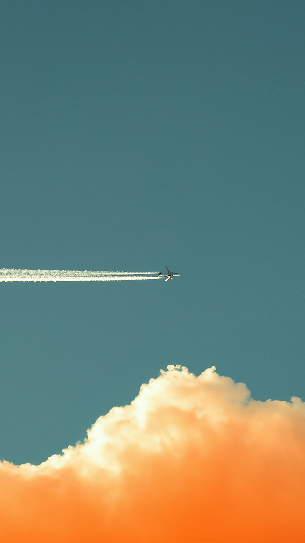 Un avión vuela en el cielo con un rastro de humo detrás de él