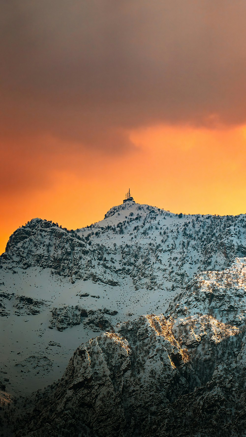 uma montanha coberta de neve sob um céu nublado