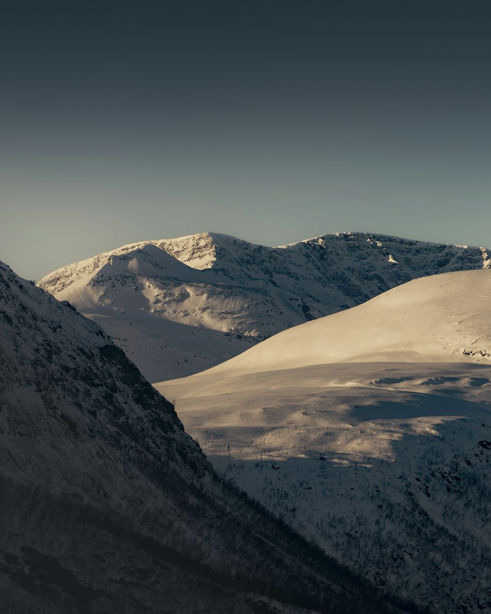 a snow covered mountain range with a sky background