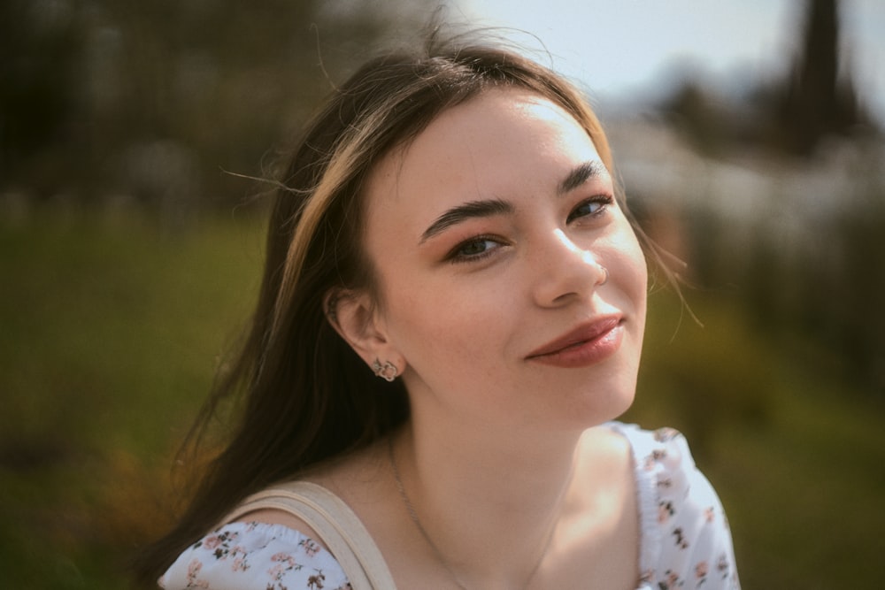 a woman with long hair is smiling at the camera