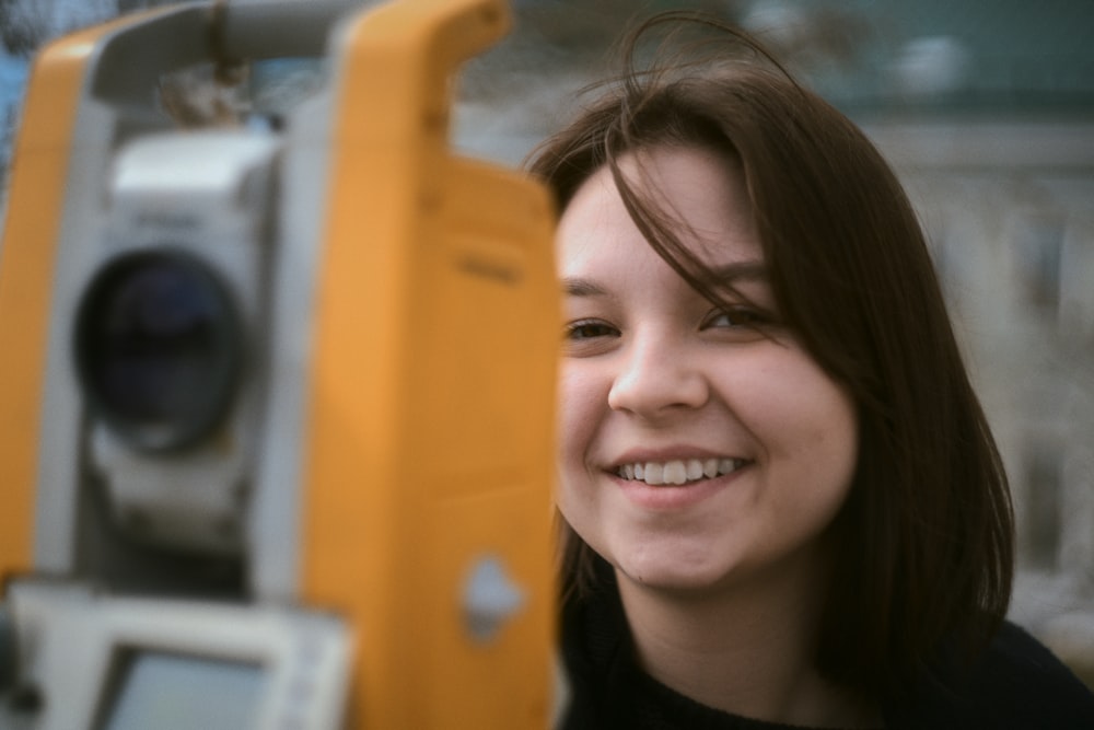 a woman is smiling next to a camera