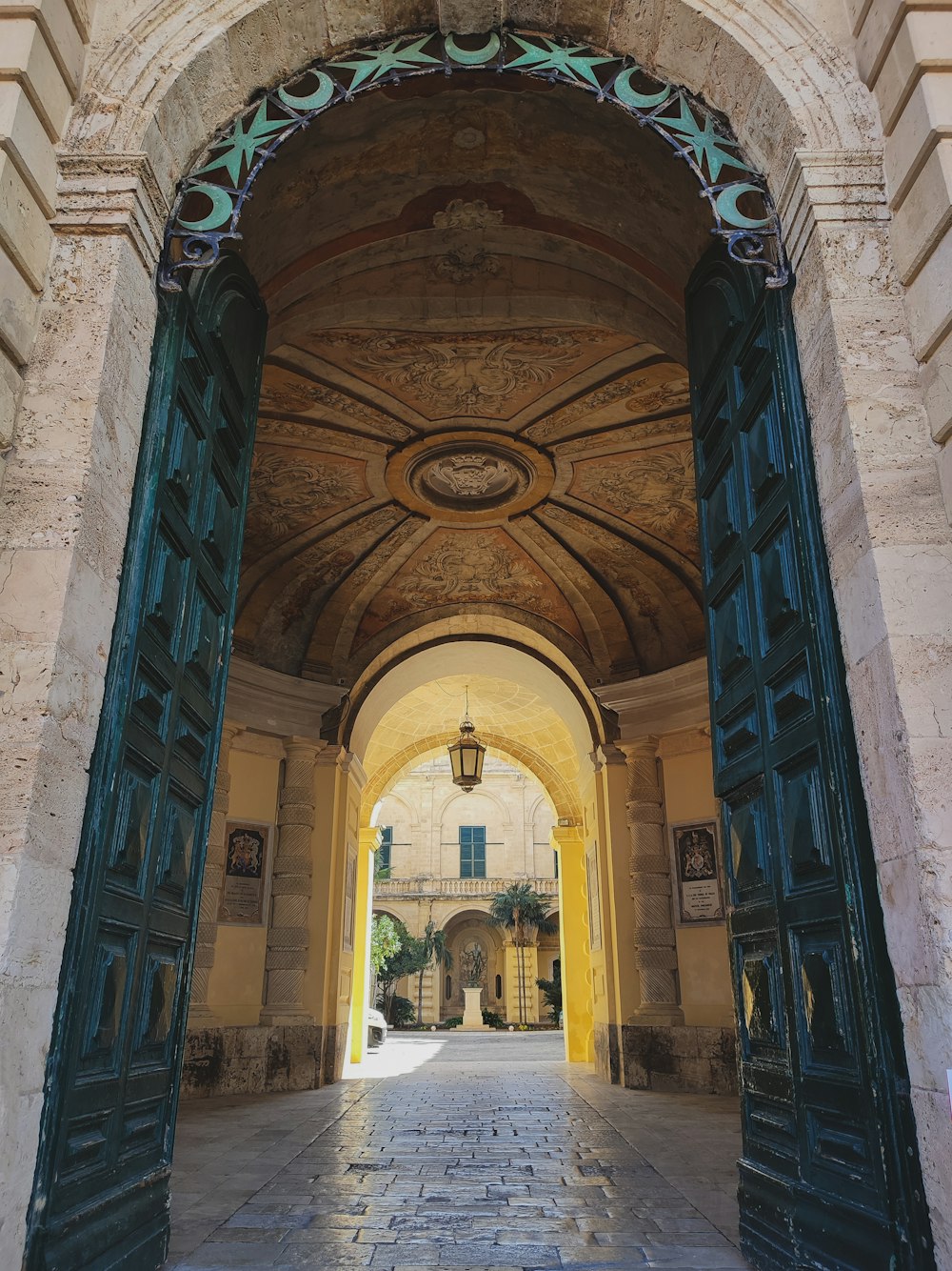 an archway leading into a building with a clock on the wall