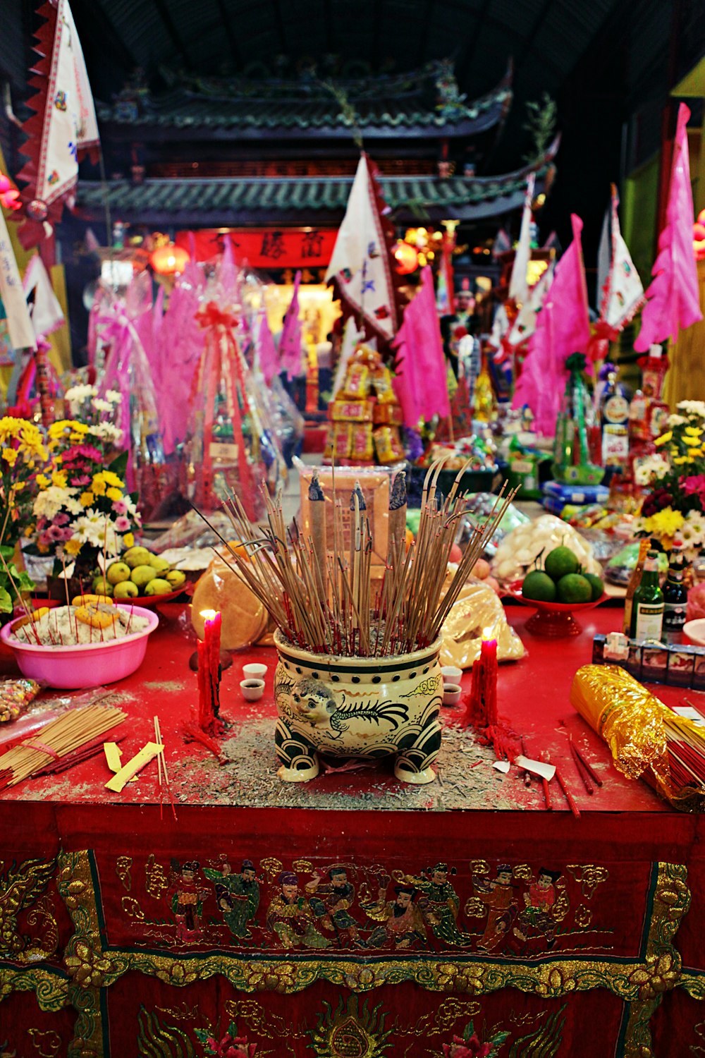 ein roter Tisch mit einer Vase voller Blumen
