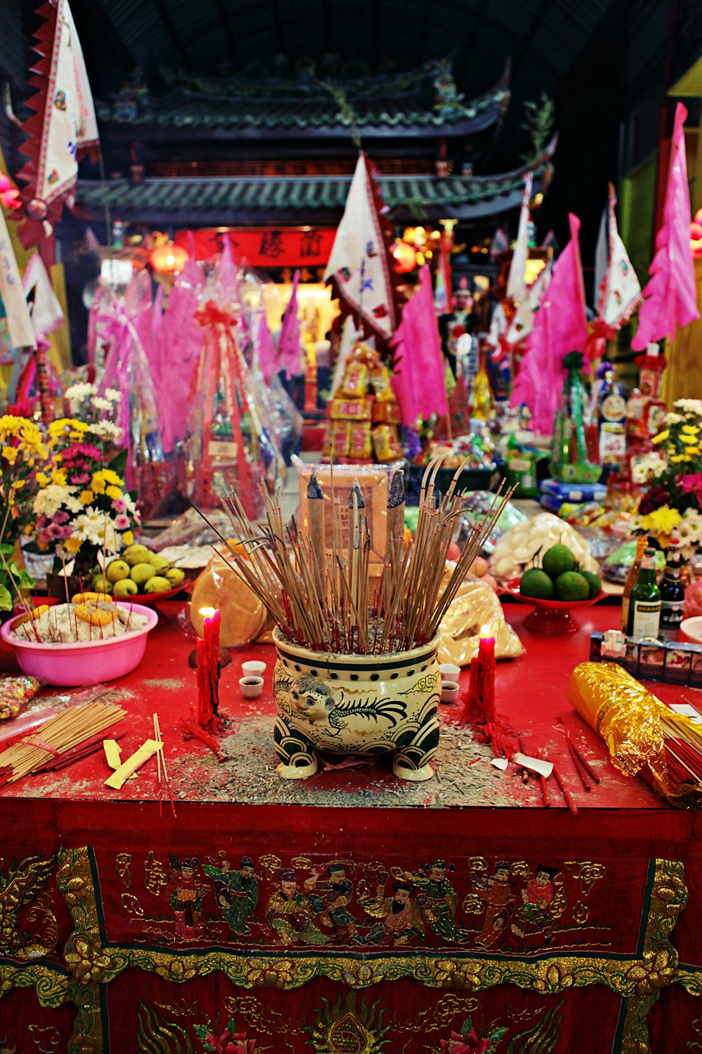 a red table topped with a vase filled with flowers