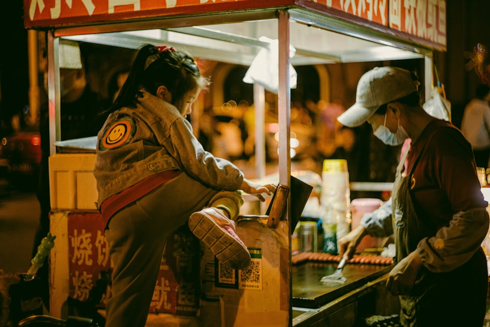 a woman standing next to a man at a food stand