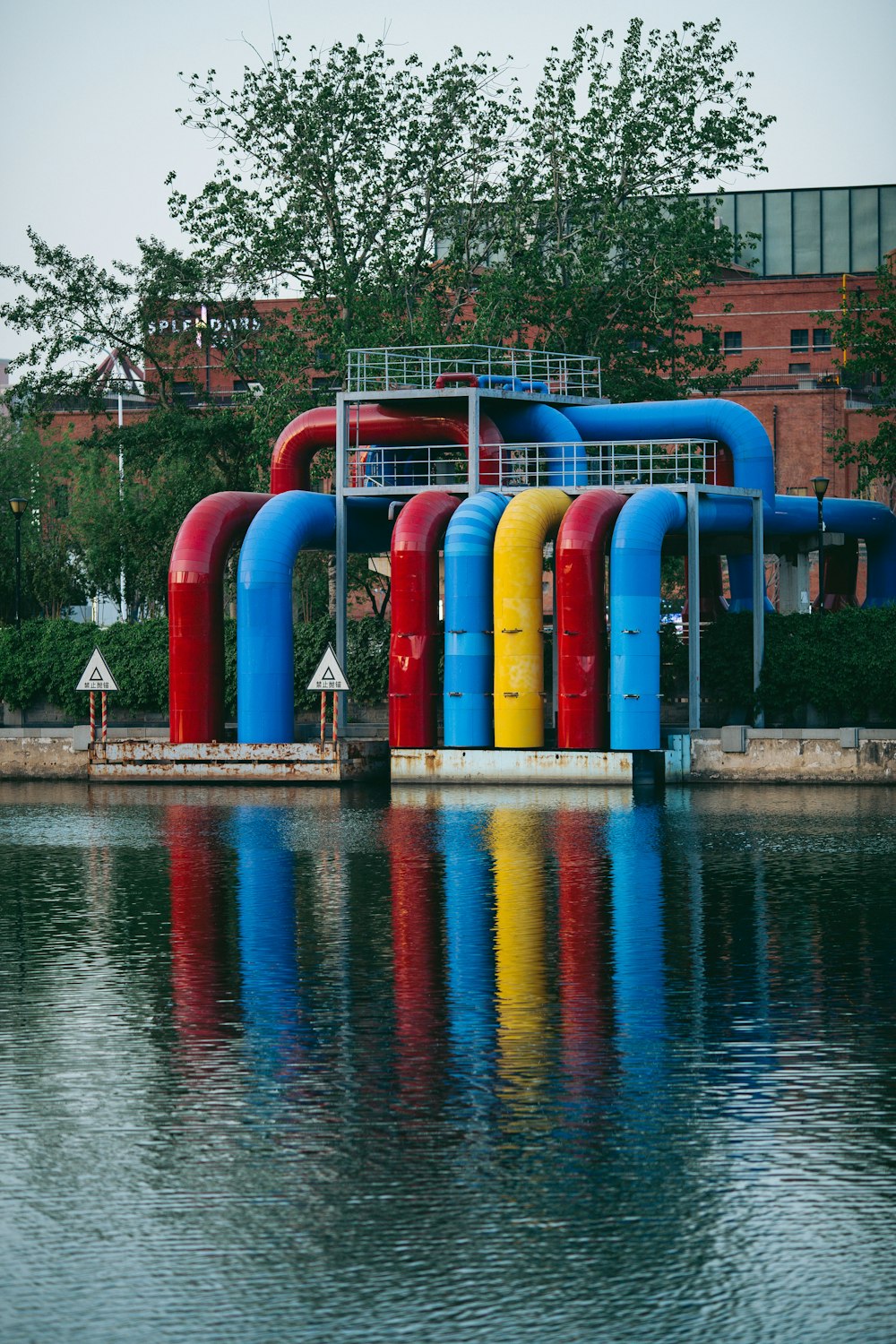 a group of colorful pipes sitting on top of a body of water