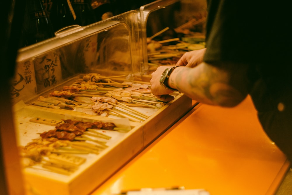 a person standing in front of a display of food