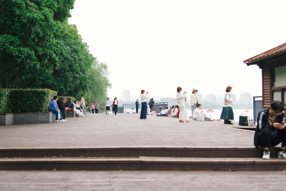 Eine Gruppe von Menschen, die in einem Park sitzen und stehen