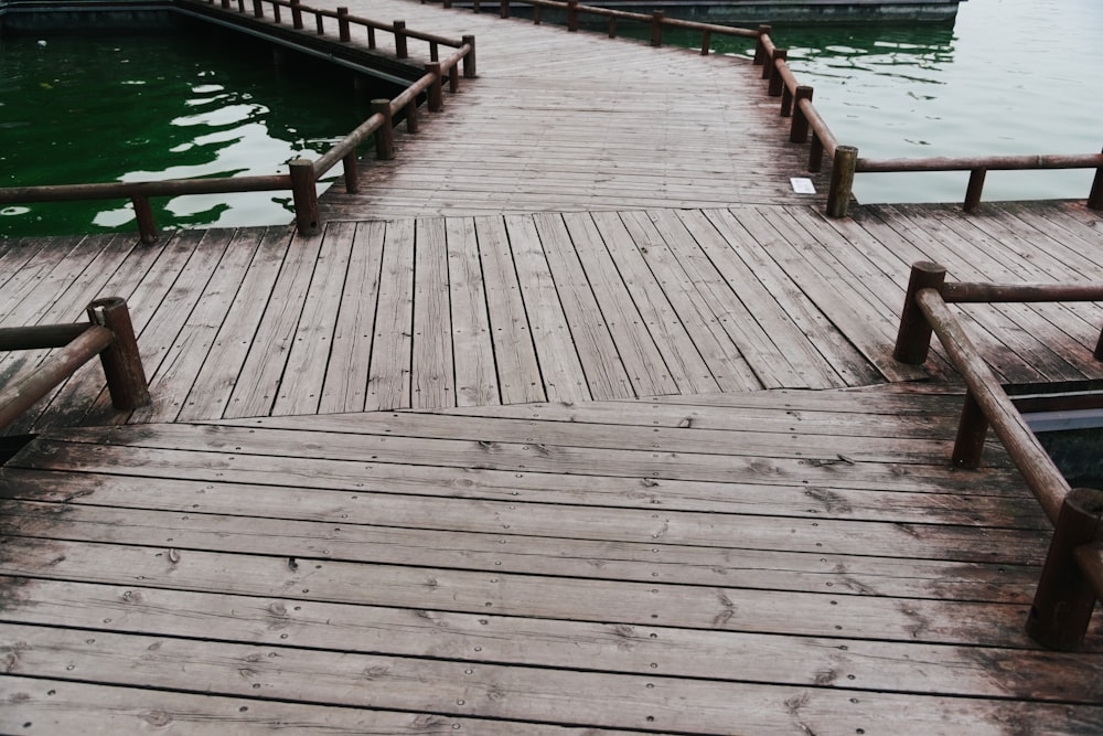 a wooden dock with benches on it next to a body of water