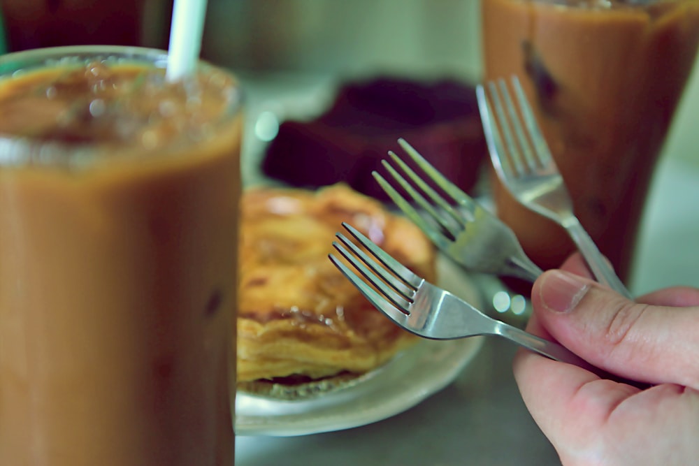 a person holding a fork over a plate of food