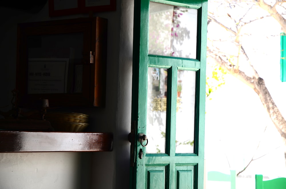 a green door in a room with a tree in the background