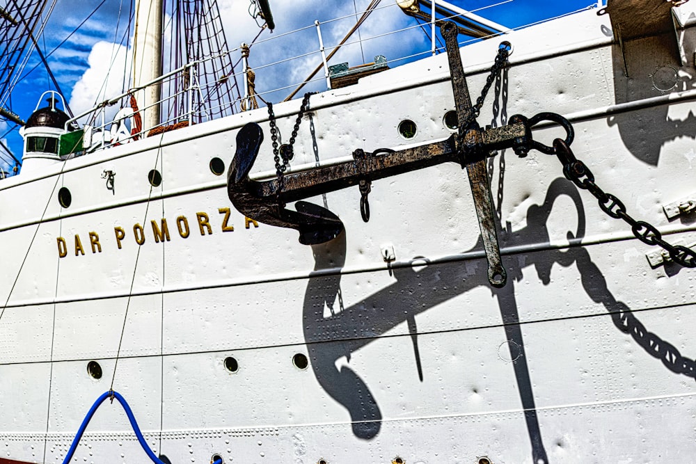 a large white boat with a black anchor on it's side