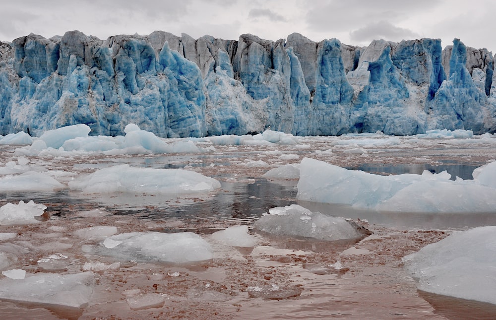 a group of icebergs floating on top of a body of water