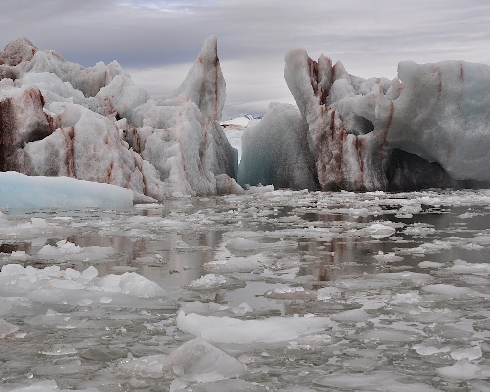 a group of icebergs floating on top of a body of water