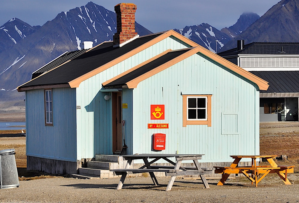 a small blue building with a picnic table in front of it