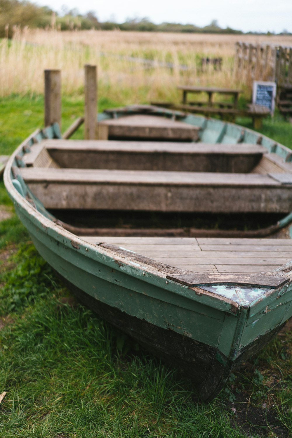 a row boat sitting on top of a lush green field