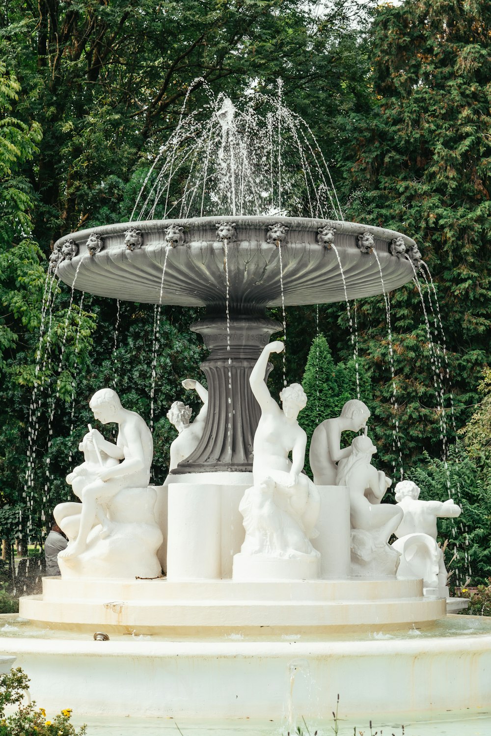 a fountain in a park surrounded by trees