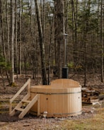 a wooden hot tub in the middle of a forest