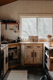 a kitchen with a sink, stove, dishwasher and a window