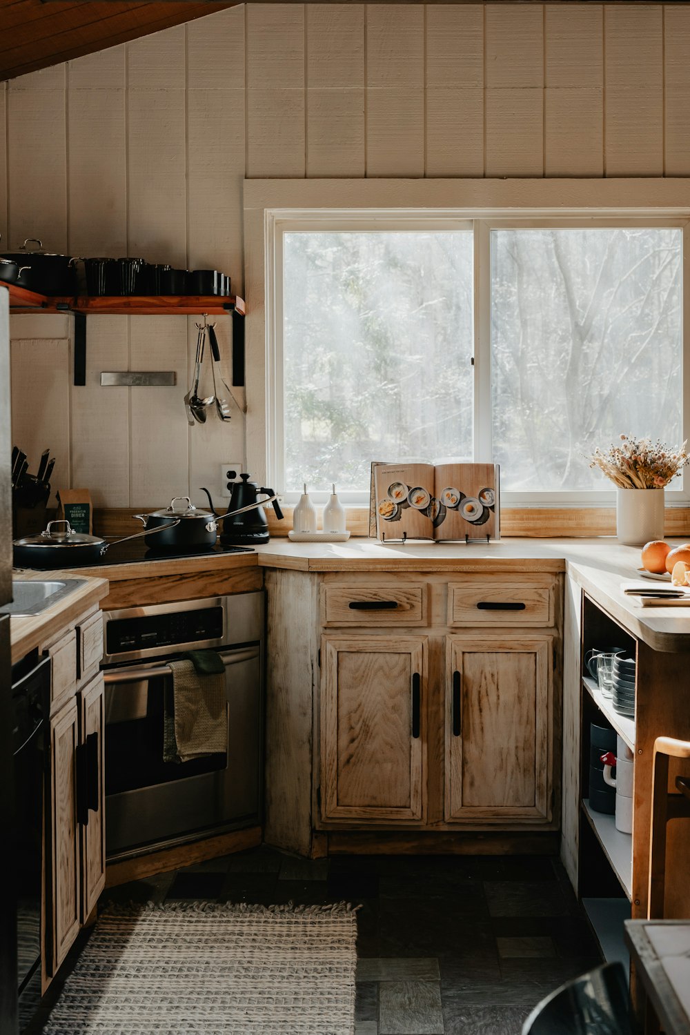 a kitchen with a sink, stove, dishwasher and a window