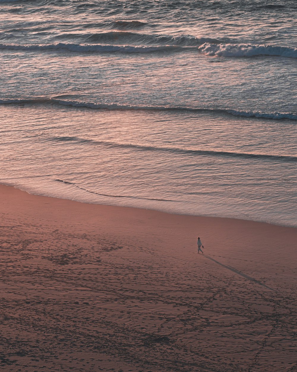 a person walking on a beach near the ocean