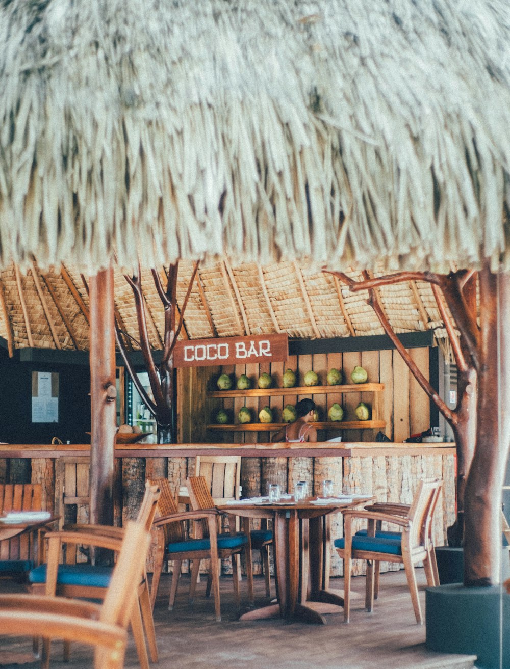 a restaurant with a thatched roof and tables and chairs