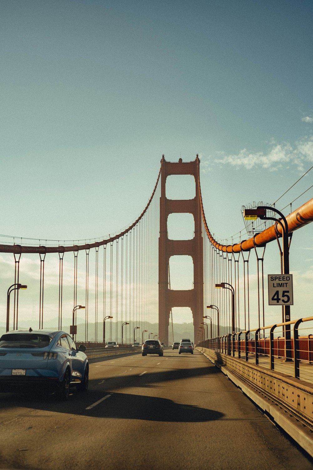 cars driving across a bridge with a traffic light