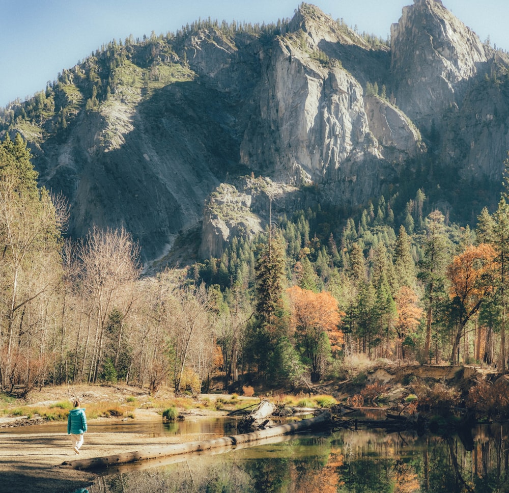 a person standing in front of a mountain lake