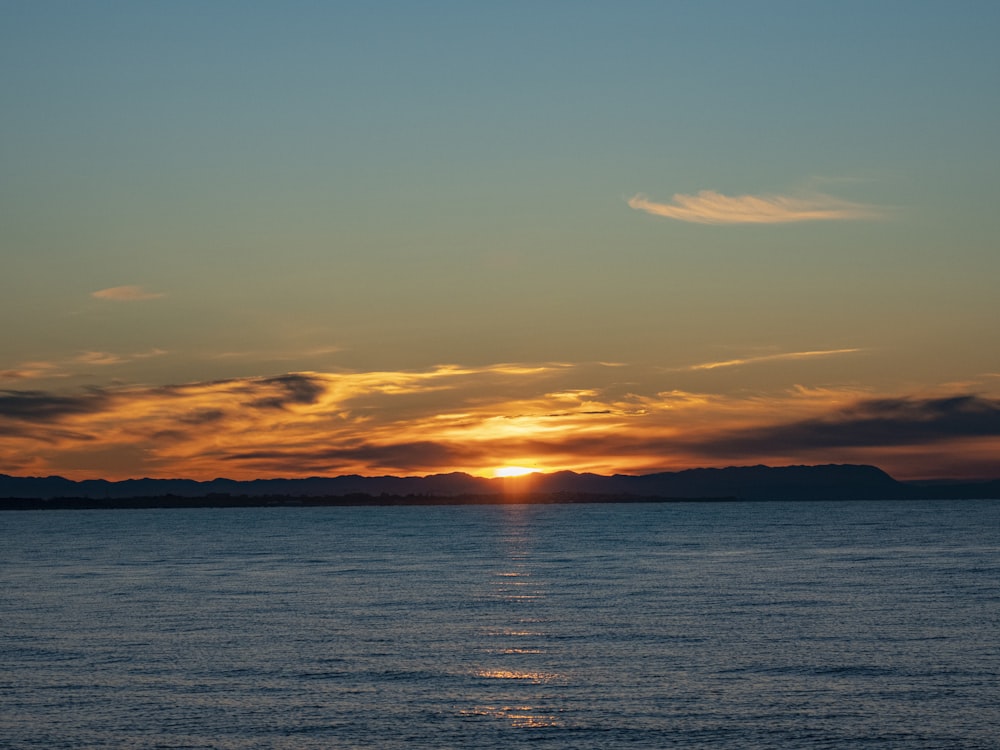 the sun is setting over a body of water