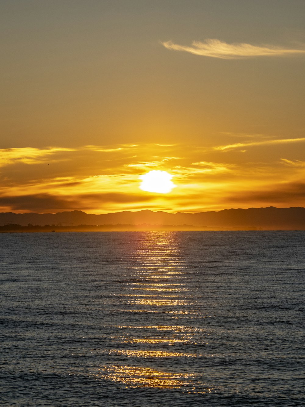 a large body of water with a sunset in the background