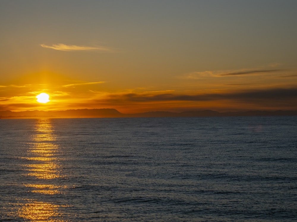 the sun is setting over the ocean on a clear day