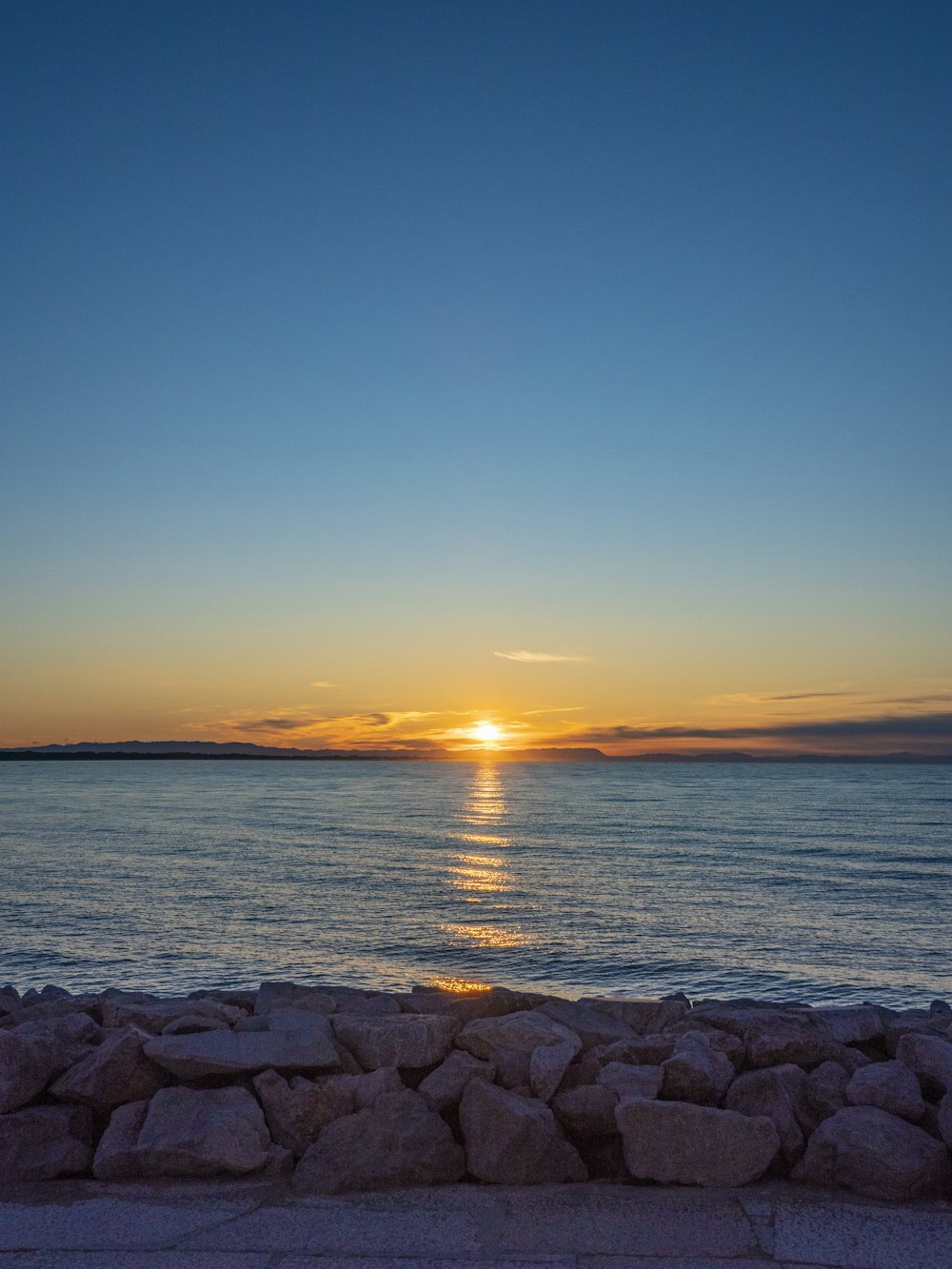 the sun is setting over a body of water