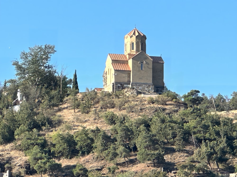 a church on top of a hill surrounded by trees