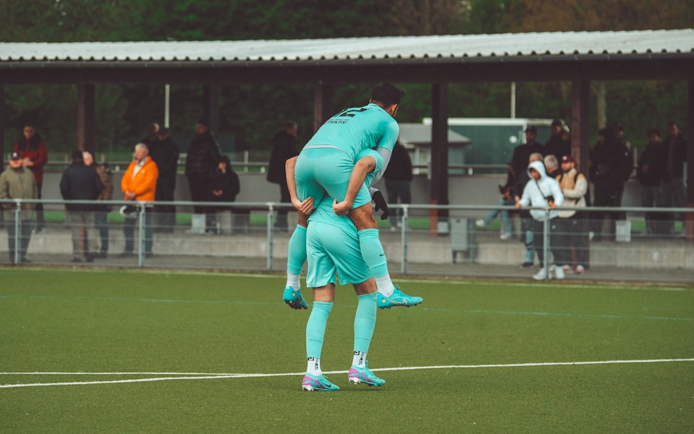 a couple of men standing on top of a soccer field