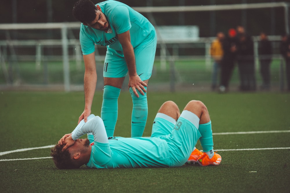 a soccer player is laying on the ground