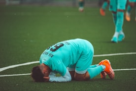 a soccer player with his head down on the ground