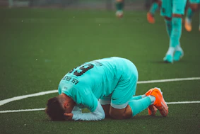 a soccer player with his head down on the ground