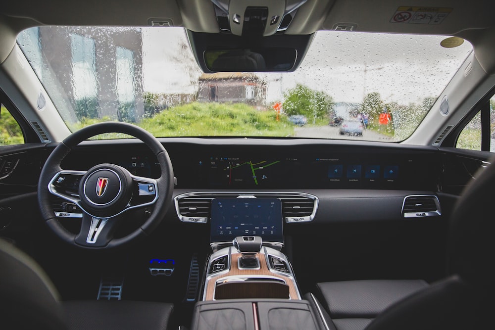 the inside of a car with a steering wheel and dashboard