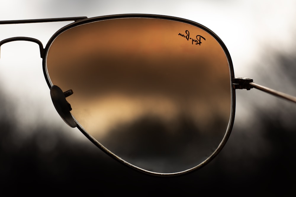 a pair of sunglasses with a reflection of a cloudy sky