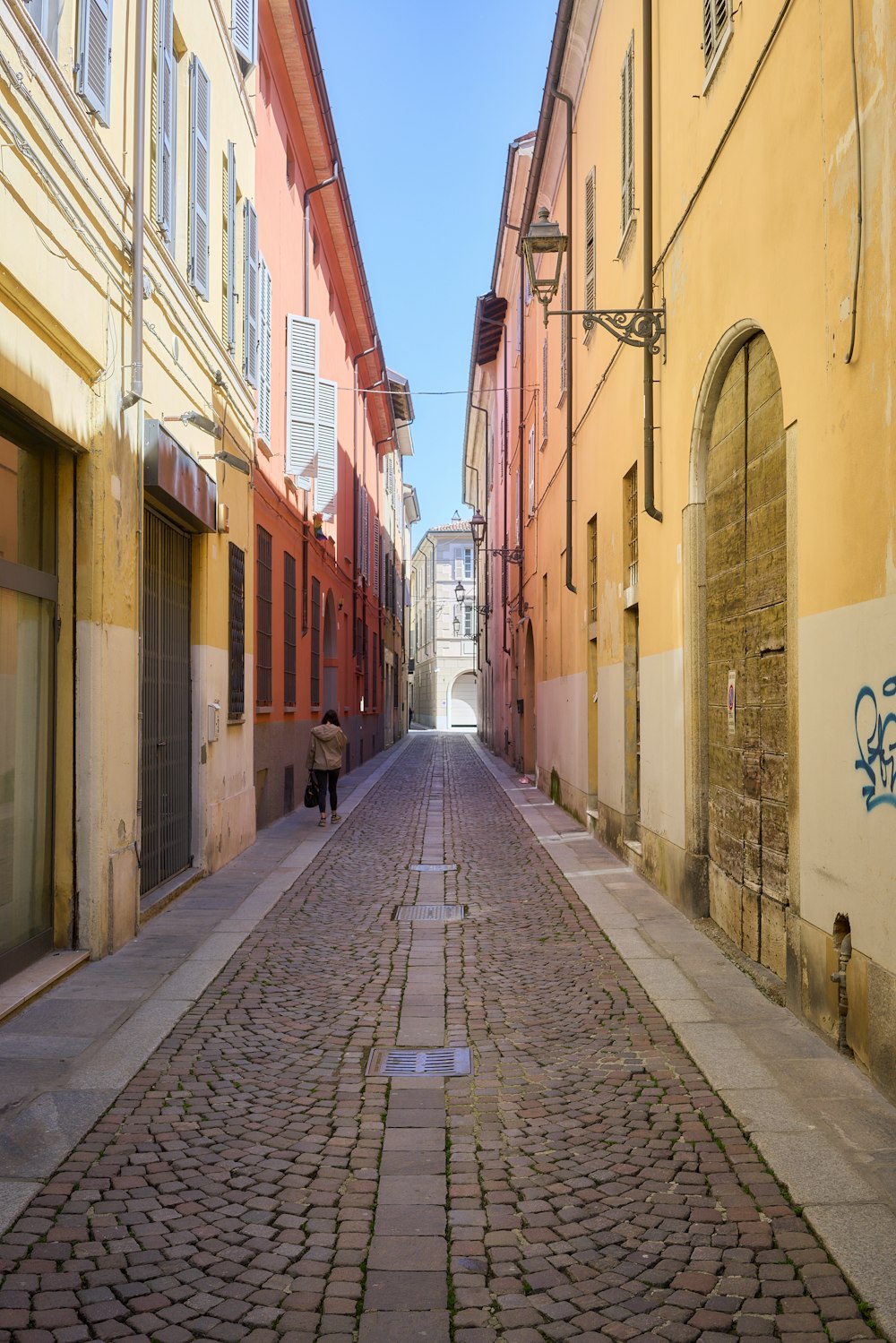 una strada acciottolata con una persona che la percorre